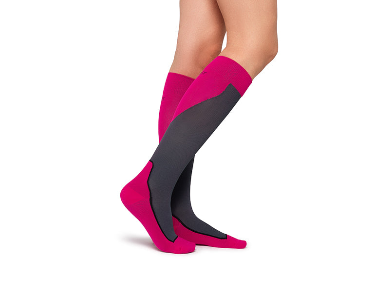 Lower legs of model in JOBST Sport compression socks in pink (side view).