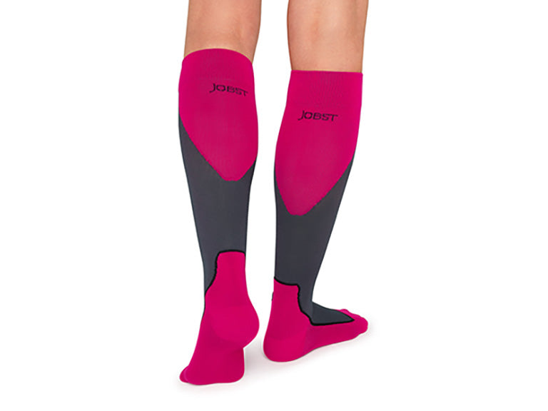 Lower legs of model in JOBST Sport compression socks in pink (back view).