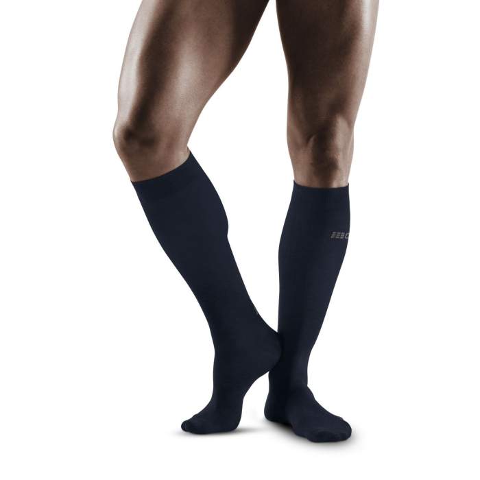 Lower legs of male model wearing knee-high CEP AllDay recovery compression socks in dark blue.