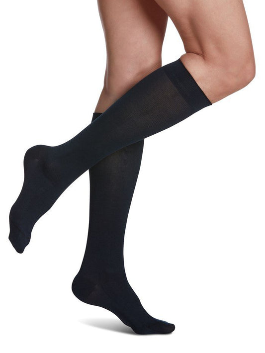 Legs of female model in Sigvaris Sea Island Cotton compression socks in navy.