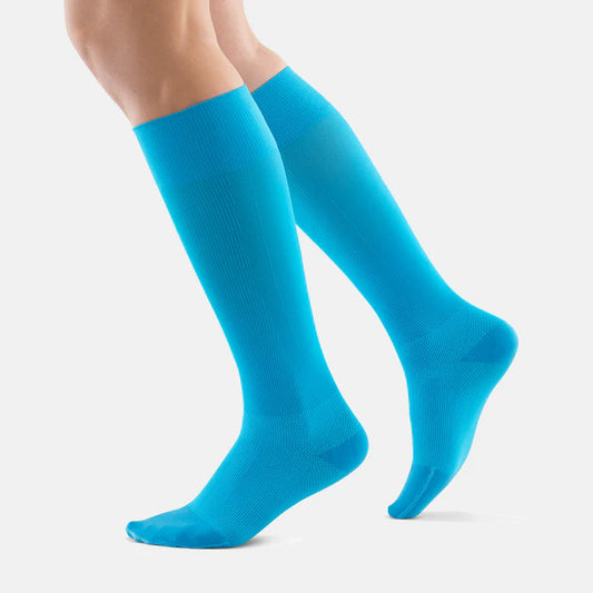 Lower legs of a model in rivera Bauerfeind performance compression socks standing in front of a white background.