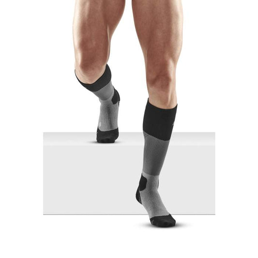 Lower legs of male model in knee-high CEP Max Cushion compression socks in grey/black.