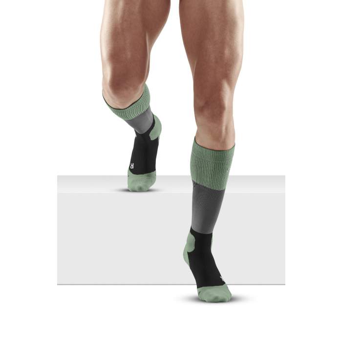 Lower legs of male model in knee-high CEP Max Cushion compression socks in grey/mint.