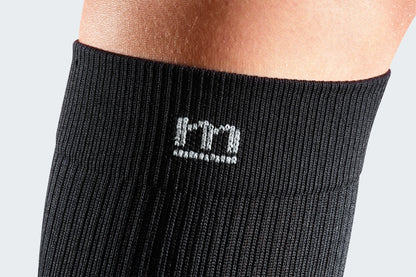 Close-up of the Mediven logo on black compression socks.