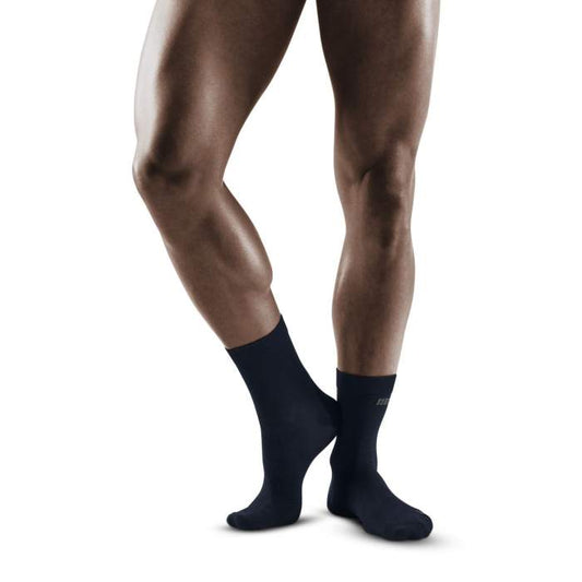 Lower legs of male model wearing mid-cut CEP AllDay recovery compression socks in dark blue.