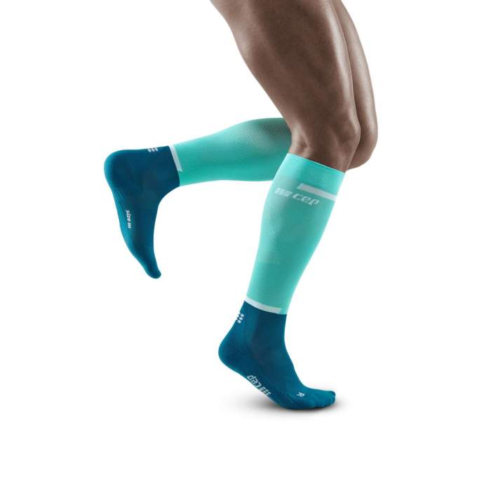 Lower legs of model in knee-high CEP The Run 4.0 compression tights in ocean/petrol.
