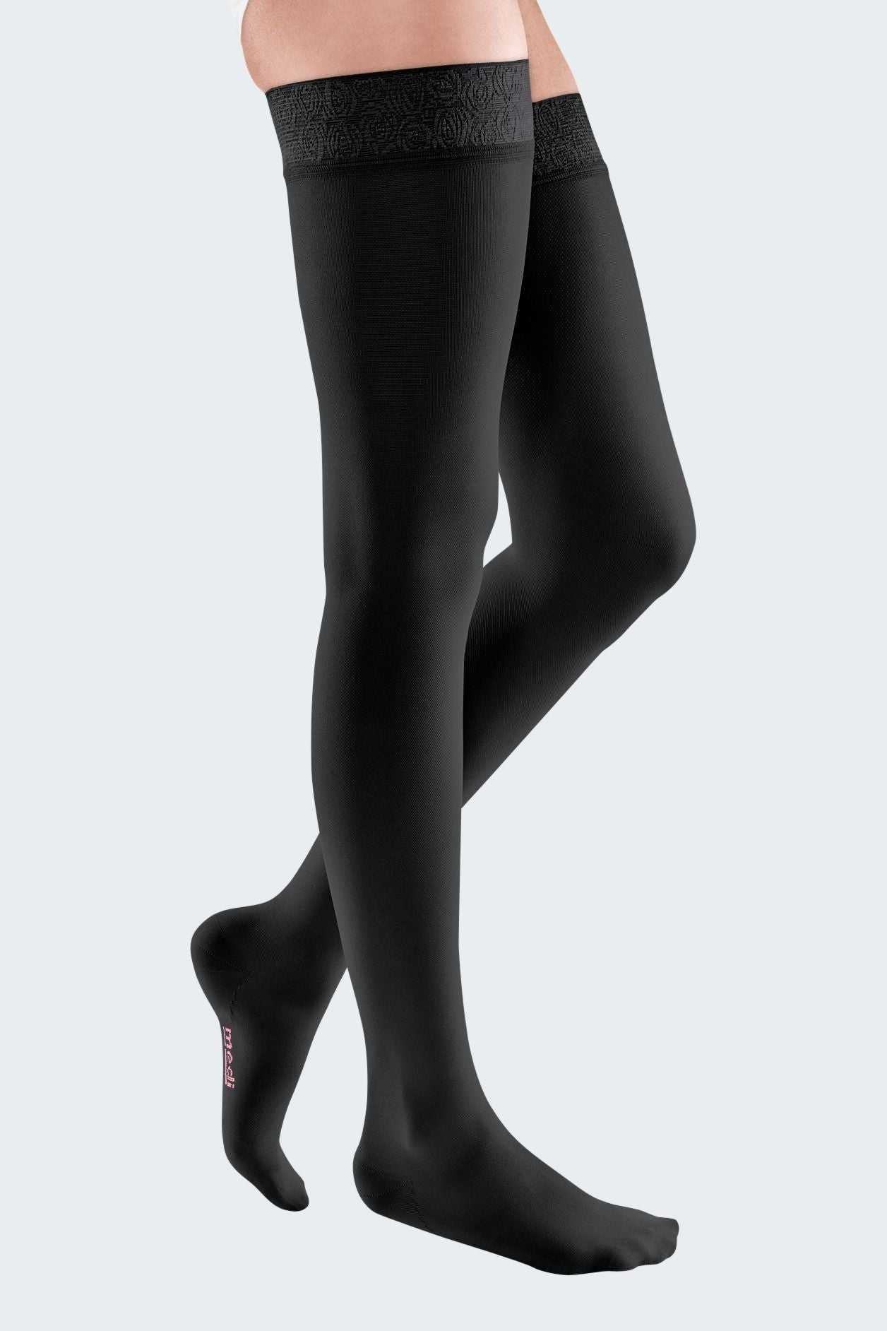 Lower body of female model in thigh-length Mediven Elegance compression tights in black.