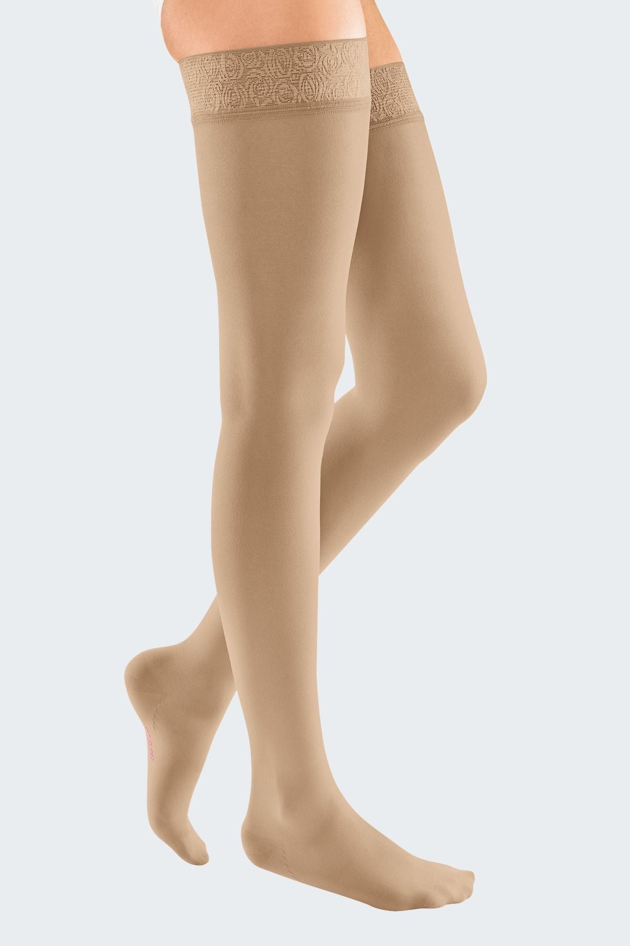 Lower body of female model in thigh-length Mediven Elegance compression tights in beige.