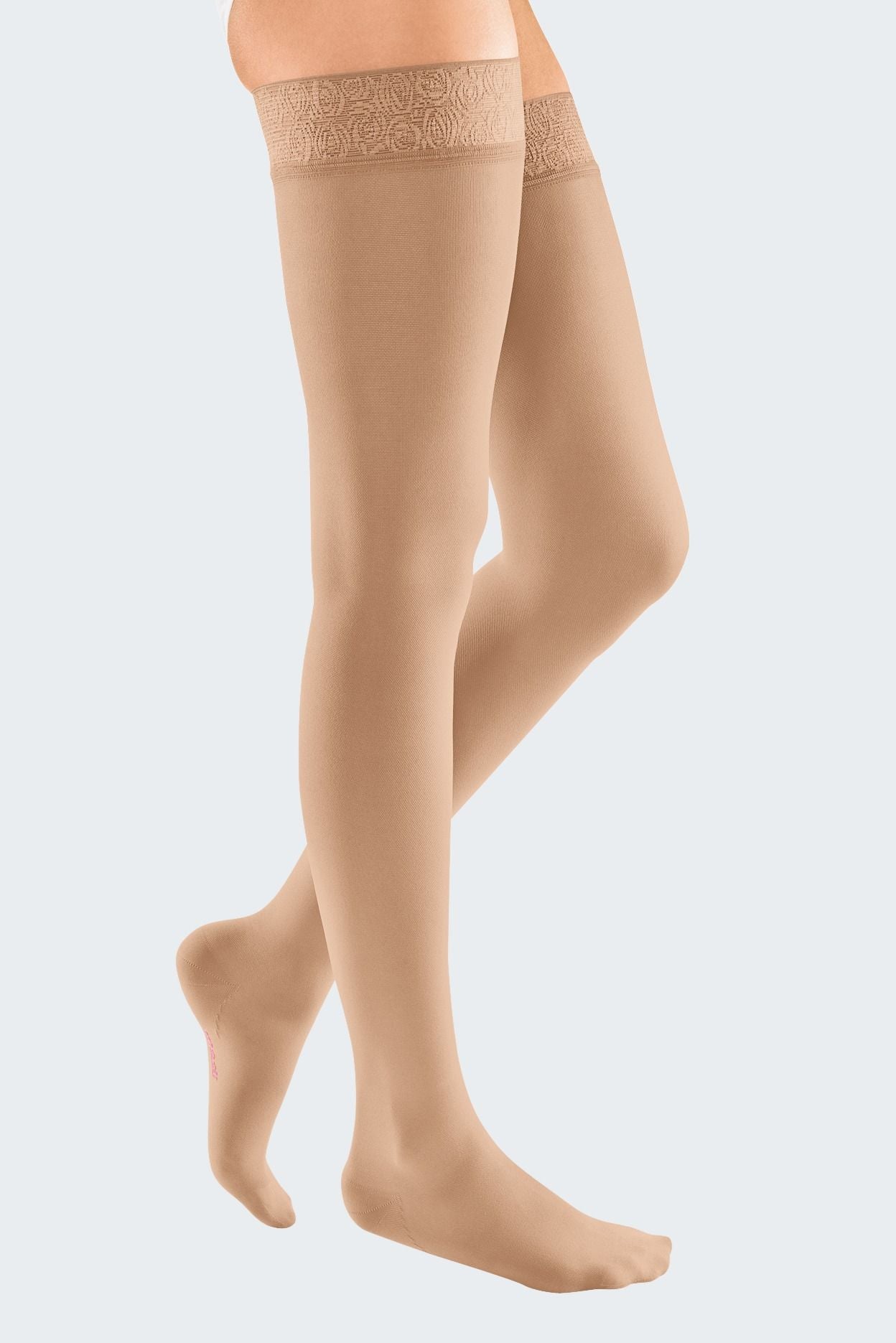 Lower body of female model in thigh-length Mediven Elegance compression tights in sand.