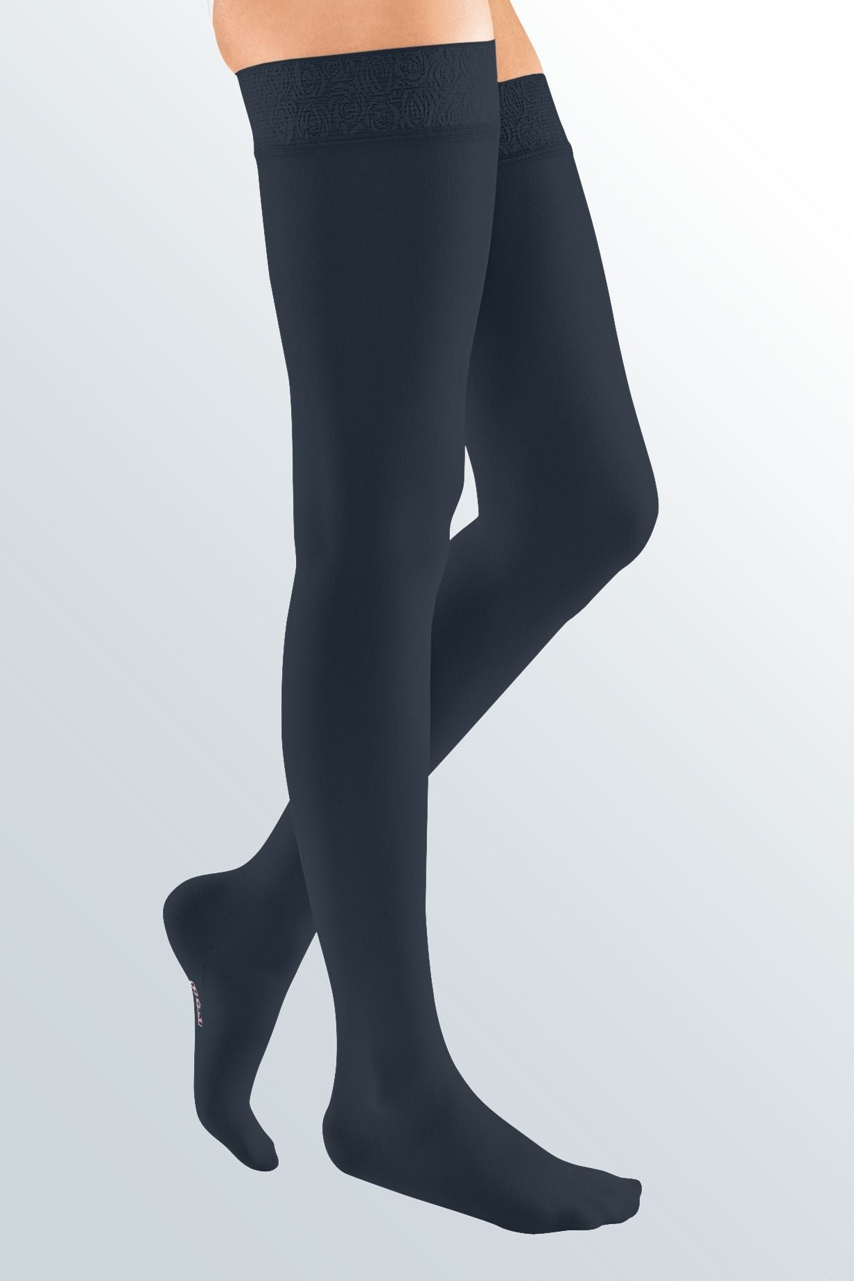 Lower body of female model in thigh-length Mediven Elegance compression tights in navy.