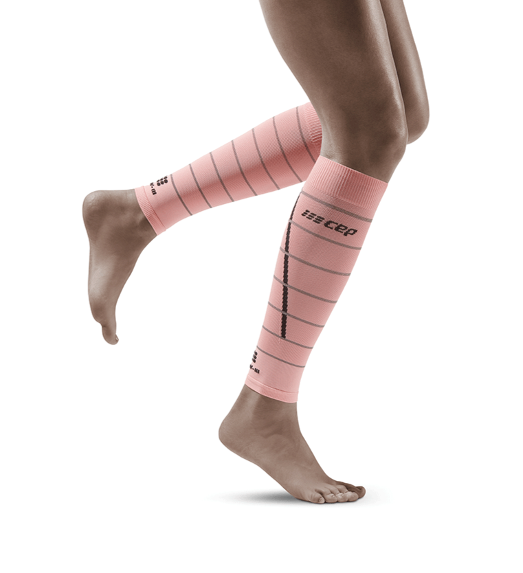 Lower legs of female model in CEP Reflective compression calf sleeves in pink.