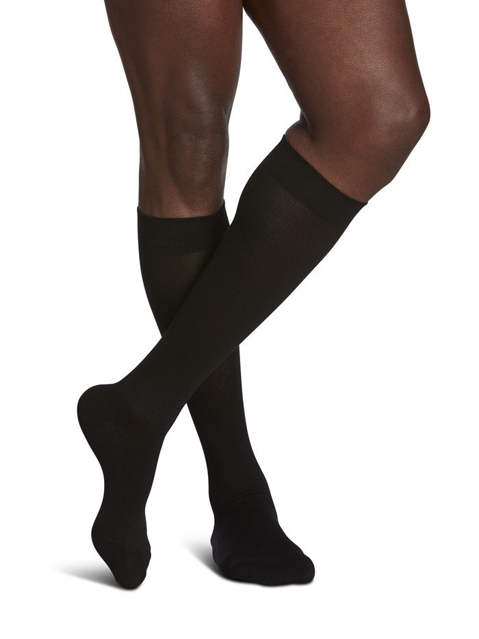 Legs of male model in Sigvaris Sea Island Cotton compression socks in black.