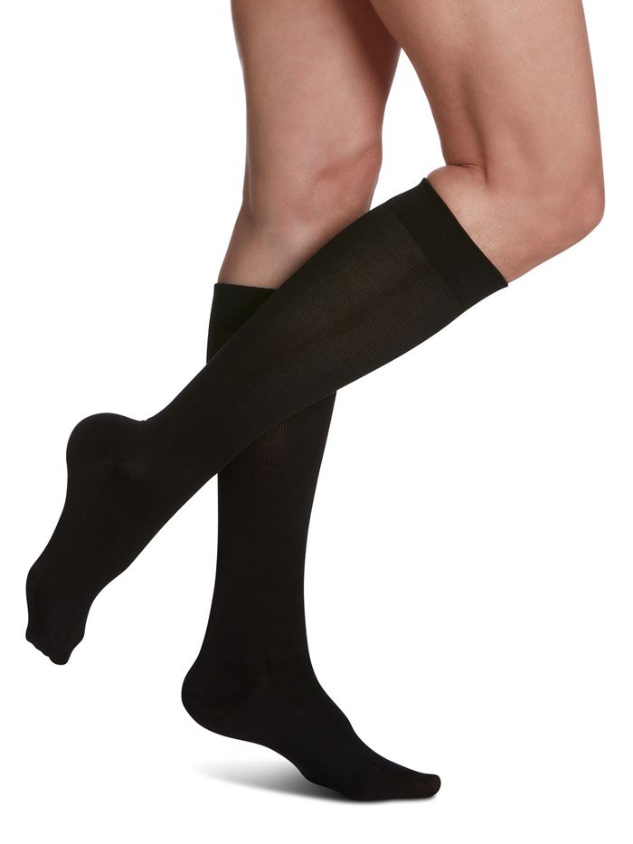 Legs of female model in Sigvaris Sea Island Cotton compression socks in black.