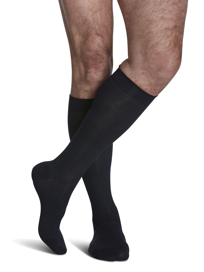 Legs of male model in Sigvaris Sea Island Cotton compression socks in navy.